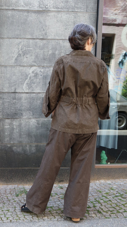 a brown Jacket in " designed to fade"cloth. there is a back yoke , movement folds and an adjustable elasticated back. Worn here with  matching Movement friendly Tali hose
